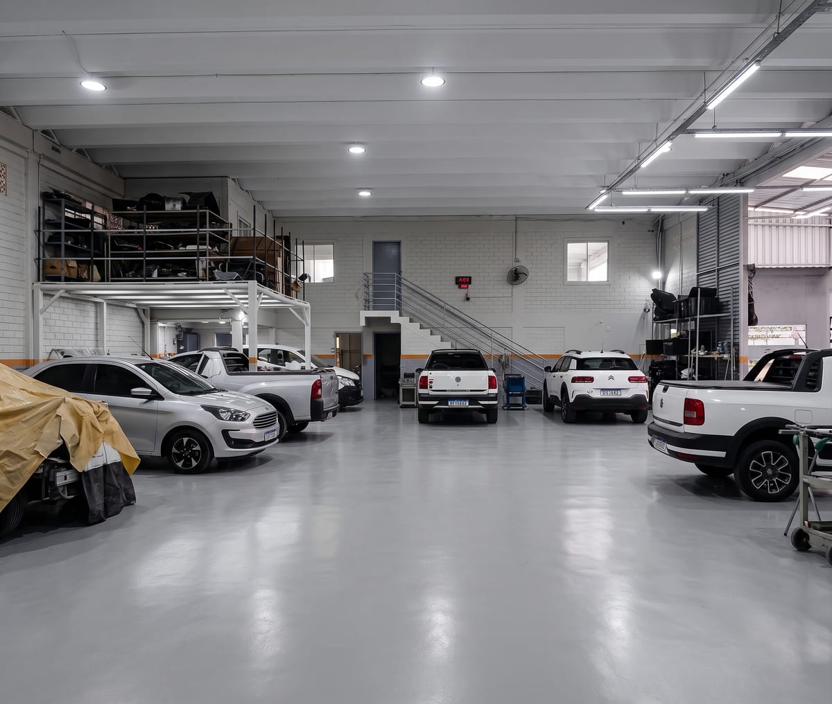 Área interna da oficina Rush Car Kobrasol, com veículos em reparo